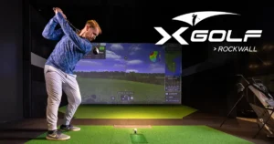 man swinging a golf club into x-golf rockwall simulators